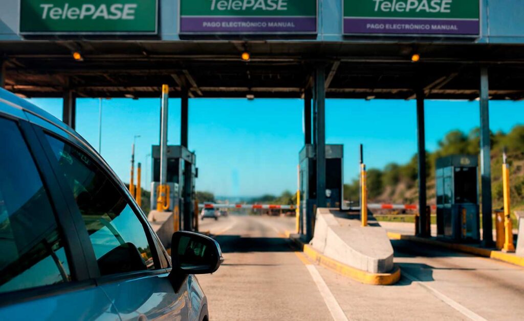 auto a punto de ingresar a una cabina de peaje en la costa argentina. se lee el cartel de telepase