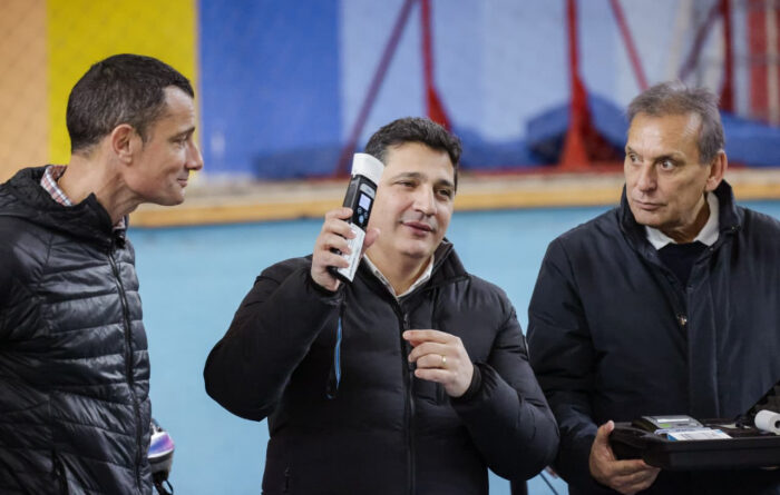 Funcionarios durante una demostración de uso de alcoholímetro en el interior de una instalación deportiva en General Rodríguez.