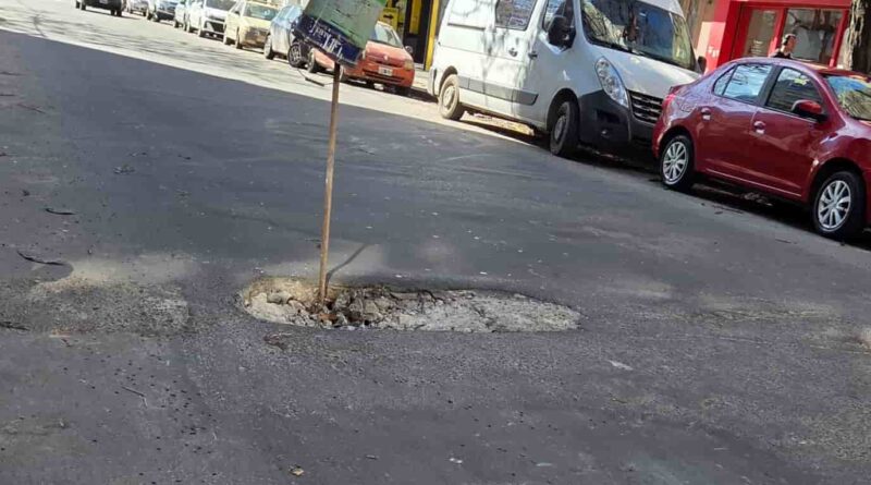 Grupo de ciclistas circulando por el carril derecho de la autopista Panamericana, con un puente peatonal y cartelería de ATASA al fondo.
