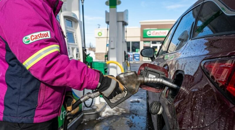 Un empleado de estación de servicio con uniforme violeta y logo de Castrol carga combustible en un automóvil oscuro. Al fondo se observa una estación BP con cartelería de Castrol