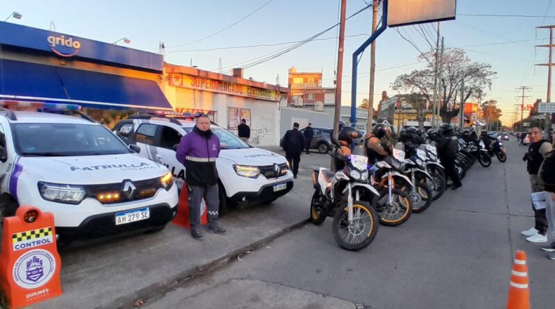 Vehículos y motos de la Patrulla Urbana de Quilmes desplegados en un operativo de control vial y ordenamiento urbano sobre avenida comercial.