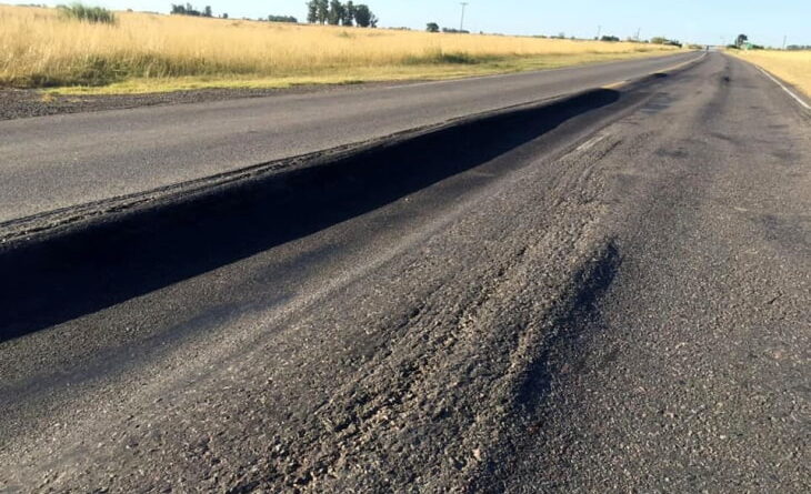 Ruta provincial 50 con bacheo asfáltico parcial: franja de asfalto fresco sobre calzada desgastada con agregado suelto.