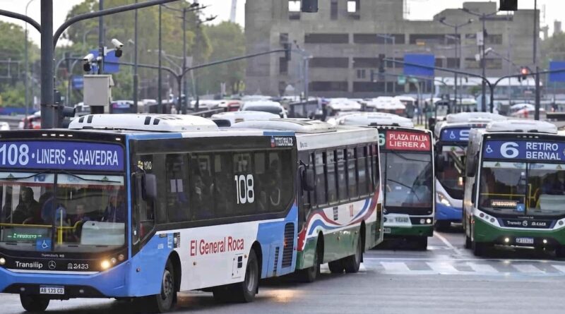 Columna de colectivos urbanos en avenida de Buenos Aires: en primer plano la línea 108 con destino Liniers-Saavedra de la empresa El General Roca, seguida por otras unidades entre las que se distingue la línea 6 con destino Retiro-Bernal. Tránsito denso en día nublado.