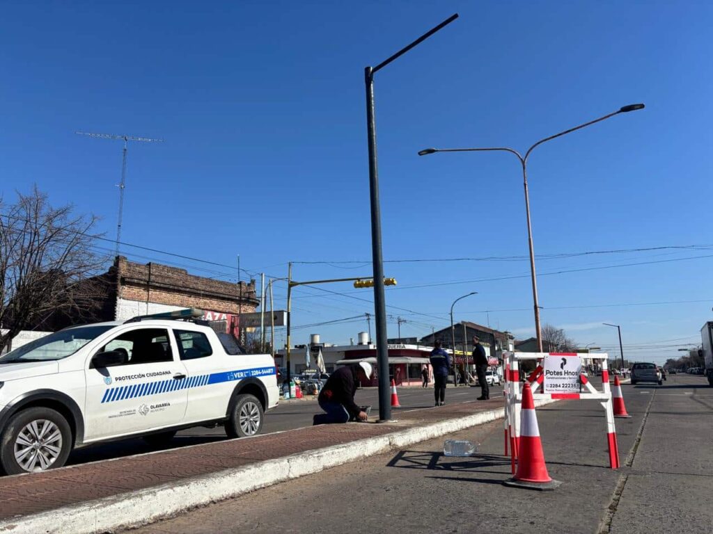 Trabajadores municipales instalan detectores de velocidad en una intersección de Olavarría, con cones de seguridad, vallas y una camioneta de Protección Ciudadana del Municipio de Olavarría custodiando la obra.