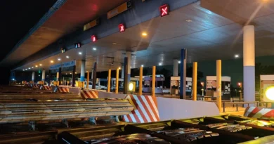 Peaje Larena de noche con carriles cerrados y materiales de obra apilados frente a las cabinas.