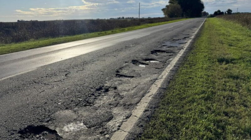 Ruta Provincial 65 con múltiples baches y asfalto deteriorado en zona rural bonaerense.