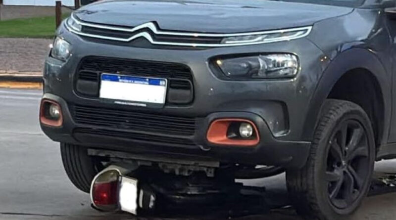 Automóvil Citroën C3 gris sobre una motocicleta aplastada tras un choque en 9 de Julio, con restos del vehículo menor visibles debajo del paragolpes.