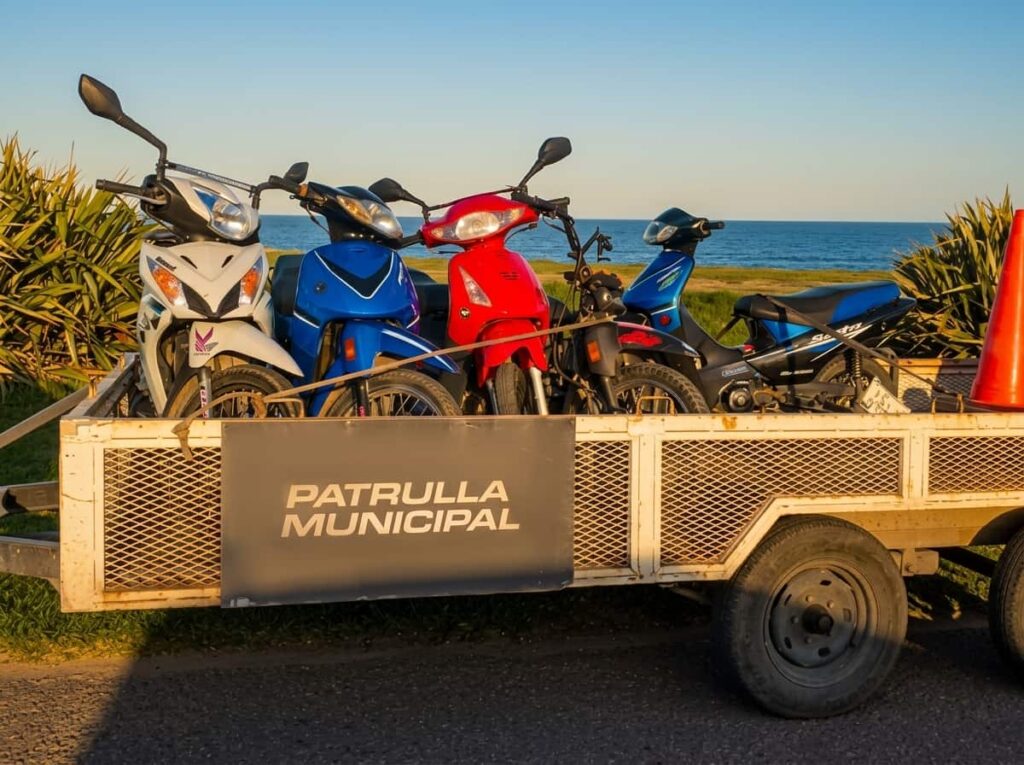 Motocicletas retenidas en acoplado de la Patrulla Municipal de Mar del Plata durante operativo de tránsito, con el mar de fondo.
