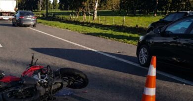 Motocicleta siniestrada sobre la calzada de la Ruta 2, con cono de señalización y vehículos detenidos tras un choque.